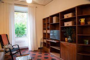 a living room with a large book shelf with a television at Piazza Testaccio Home appartamento E 1 accogliente con vista piazza Testaccio in Rome