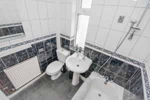 uma casa de banho com um WC, um lavatório e uma banheira em K Suites - Arthur Street Doncaster em Bentley