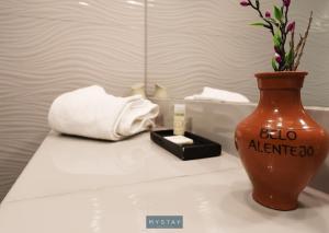 a vase sitting on a table with a candle and a towel at MyStay - Casa de Baco in Igrejinha +24 photos