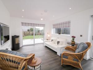 19A Lismenary Road في Ballyclare: غرفة معيشة مع أريكة بيضاء وكراسي