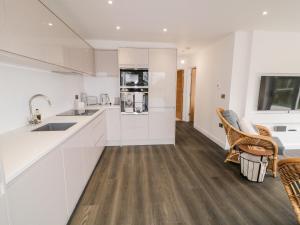 una cucina con pareti bianche e pavimenti in legno di 19A Lismenary Road a Ballyclare