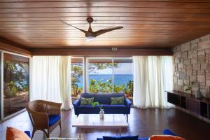 a living room with a couch and a ceiling fan at Frenchman's Cove Resort in Port Antonio