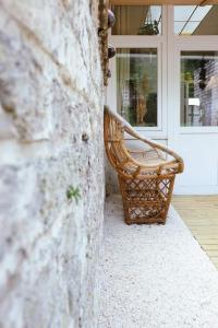 a wicker bench sitting in front of a door at Superbe appartement avec cheminée in Verviers