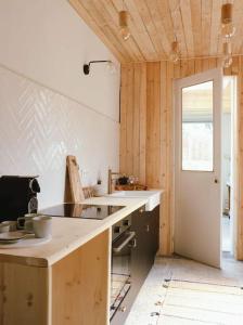 cocina con paredes de madera y encimera en Superbe appartement avec cheminée, en Verviers