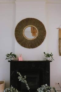 a mirror on a wall above a fireplace at Superbe appartement avec cheminée in Verviers