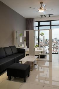 a living room with a couch and a table at Penang KTHOME Beacon Executives suite in George Town
