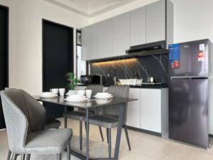 Una cocina con mesa y sillas y un refrigerador. en Urban Suites - George Town, Penang, en Jelutong