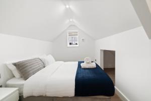 a white bedroom with a bed and a couch at High Standard City Center Leicester in Leicester