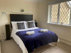 a bedroom with a large bed with two towels on it at Pass the Keys Cosy 2BR Home in Walton in Walton-on-Thames