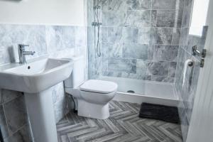 a bathroom with a sink and a toilet and a tub at 3BD Gem in the Heart of Barnetby Le Wold in Barnetby le Wold