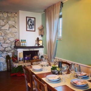 einem Tisch mit Gläsern und Tellern sowie einem Kamin in der Unterkunft Bed&Breakfast La Ginestra in Abbateggio