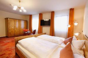 a hotel room with two beds and a television at Gasthof Krone Fladungen in Fladungen