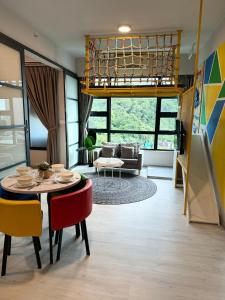 Una sala de estar con una mesa y sillas y un sofá. en JQ#05 City View Slide LoftBed 2R1B 5pax near Suria Mall, Gaya St, SICC, en Kota Kinabalu