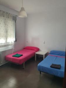 2 camas en una habitación con rojo y azul en FORTUNATO ARIAS 17, en Hellín