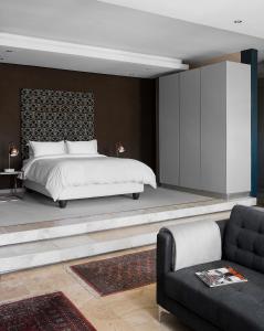 a bedroom with a large bed and a couch at The Franklin Loft Apartments Johannesburg in Johannesburg