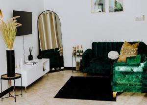 sala de estar con sofá verde y espejo en LM Apartments en Dar es Salaam