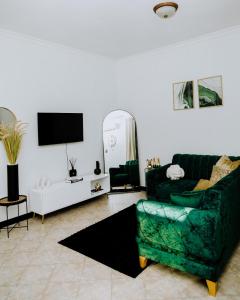 a living room with a green couch and a tv at LM Apartments in Dar es Salaam