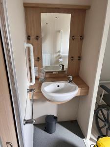 a bathroom with a sink and a mirror at Luxurious Wheelchair-Friendly holiday home at Kent Coast Holiday Park in Allhallows