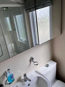 a bathroom with a sink and a mirror at Luxurious Wheelchair-Friendly holiday home at Kent Coast Holiday Park in Allhallows