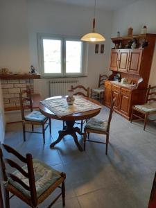 a room with a table and chairs and a kitchen at Ca' LUCIANO in Castelnuovo Magra