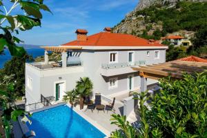 een villa met een zwembad en uitzicht op de oceaan bij Villa Vidiroti in Lokva Rogoznica