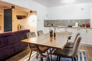 a kitchen and dining room with a wooden table and chairs at Kornmarkt Appartments in Bistriţa