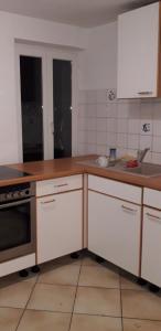 a kitchen with white cabinets and a wooden counter top at CityHome am Markt in Saarbrücken +2 photos