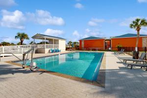 a swimming pool with two chairs and a building at Gulf Terrace 287 in Destin