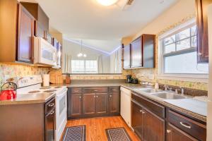 a large kitchen with wooden cabinets and a window at Charming High Point Home with Yard 4 Mi to HPU! in High Point