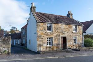 an old stone house on the side of a street at Quirky Cottage in the Heart of St Andrews in St. Andrews