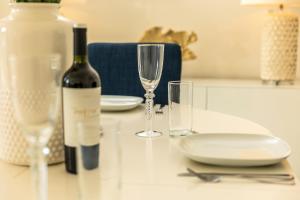 a bottle of wine and two glasses on a table at 24 Montpellier Spa Road in Cheltenham