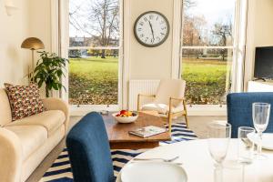 a living room with a couch and a clock on the wall at 24 Montpellier Spa Road in Cheltenham