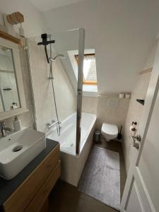 ein Badezimmer mit einem Waschbecken, einer Badewanne und einem WC in der Unterkunft Haus Renate in Timmendorfer Strand