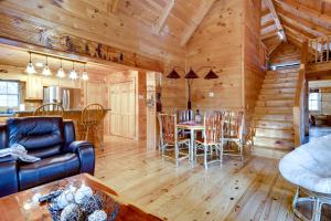 uma sala de estar com um sofá e uma mesa em Riverfront Blue Ridge Cabin with Private Hot Tub em Mill Spring