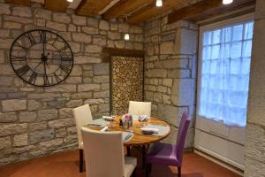 une salle à manger avec une table et une grande horloge dans l'établissement Le Relais D'arc Et Senans, à Arc-et-Senans