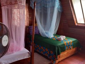 ein Schlafzimmer mit einem Himmelbett mit grünem Laken in der Unterkunft Mionga in Santa Cruz