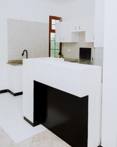a kitchen with a white and black counter top at LM Apartments in Dar es Salaam