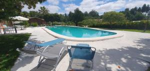 einen Pool mit 2 Liegestühlen und einem Pool in der Unterkunft Quinta Moinho do Monte in Mira