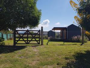 a wooden gate in a field with a house at Cantal Tiny house in Salta