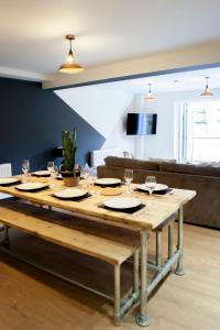una mesa con vasos y platos en la sala de estar en Cotswold's Large 4 bed house-Sleeps 10-Free Parking-Wifi 