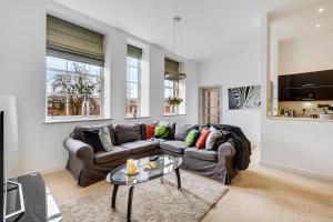 ein Wohnzimmer mit einem Sofa und einem Tisch in der Unterkunft Pass the Keys Luxury 2 Apt in West Didsbury in Manchester