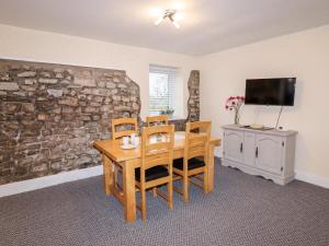 a dining room with a table and chairs and a tv at Fern Cottage in Cardiff