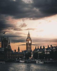 a clock tower and big ben in london at sunset at Lovely Studio- Aldgate East Stn in London