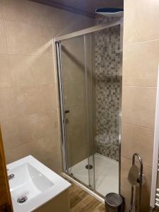 a bathroom with a shower and a sink at Casa Azul Serra da Estrela in Penhas da Saúde