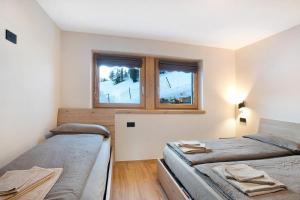 una camera con due letti e una finestra di Palipert Nature House a Livigno