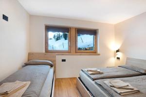 a bedroom with two beds and a window at Palipert Nature House in Livigno