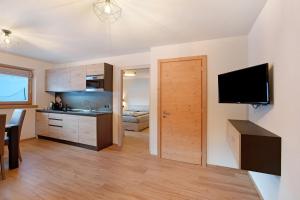 a kitchen and living room with a television and a door at Palipert Nature House in Livigno