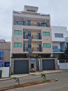 un edificio alto con garajes delante en SUITES-HOME, CIDADELA, en Praia