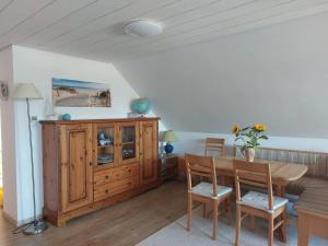 a dining room with a table and a wooden cabinet at Große, helle Wohnung mit sonnigem Balkon in Mechernich
