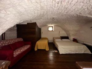 a room with two beds and a couch in a cave at La Pergola in Locorotondo